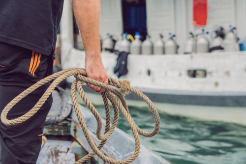 Deckhand throwing a mooring line aboard a commercial vessel